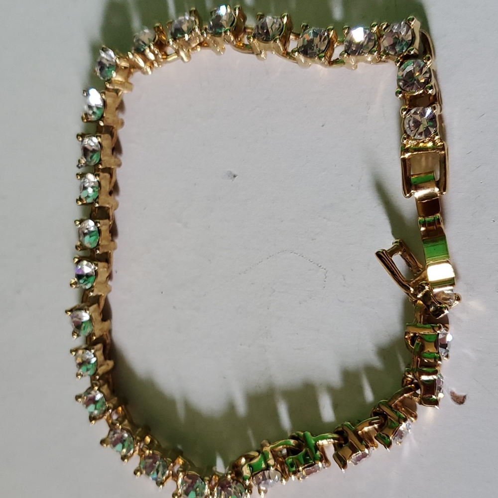 Fashion gold tone tennis bracelet with rhinestones and clasp closure